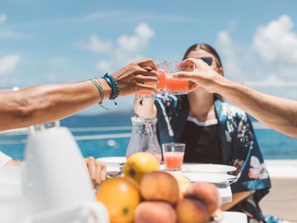 Friends enjoying drinks on catamaran sailing holiday in Greece