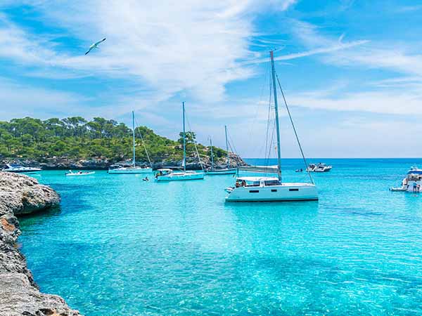 Landscape with boats and turquoise sea water on Cala Mondrago, Majorca island, Spain