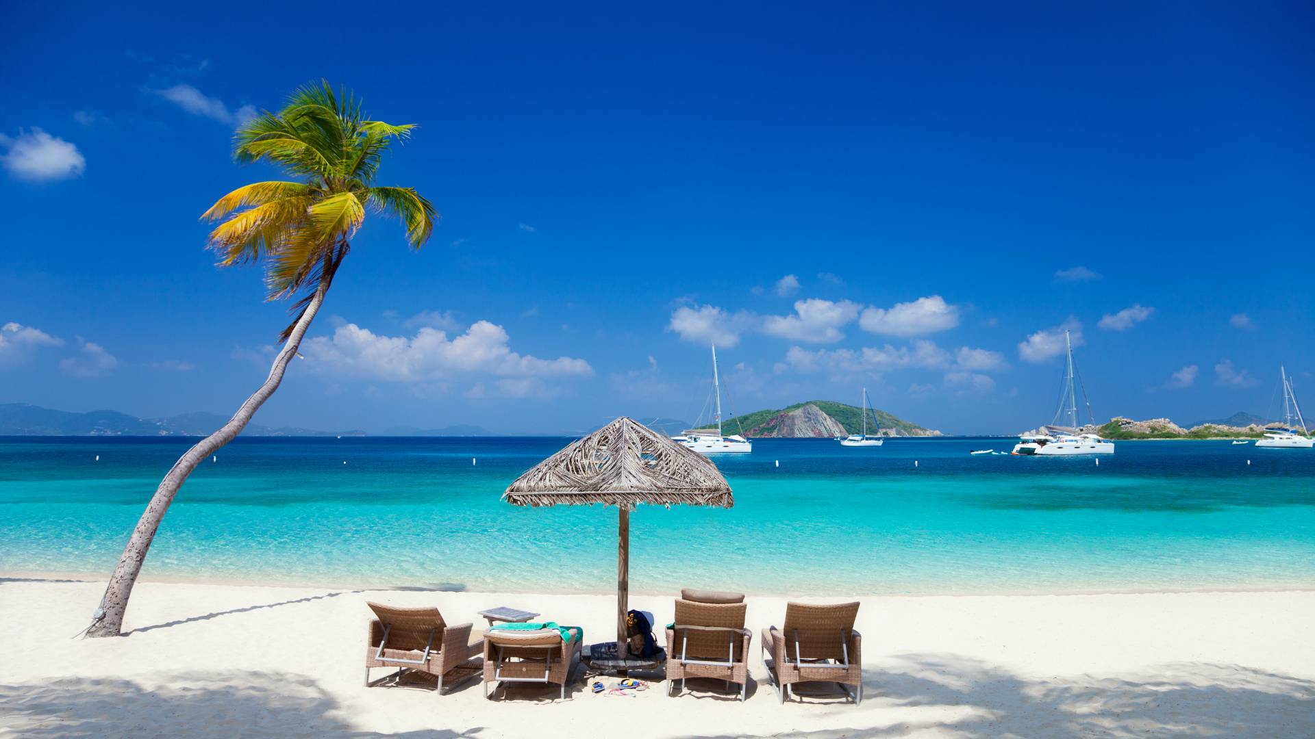 Beautiful white sand beach and catamarans at Deadman’s Cay, Peter Island, the British Virgin Islands